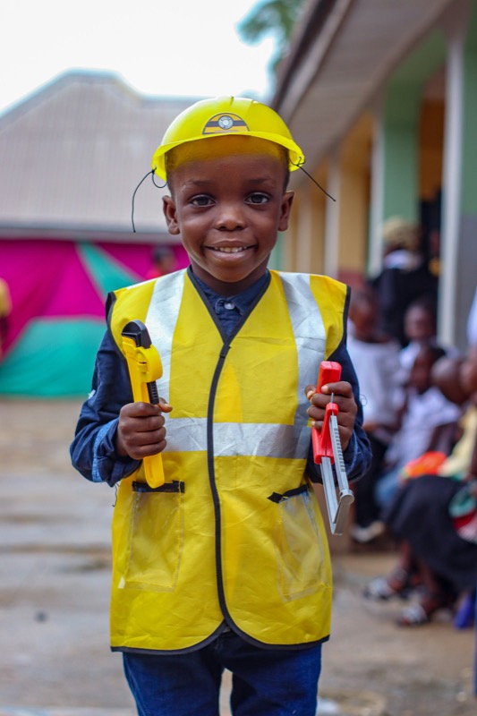 A young trade worker in safety vest, holding a tool on site.